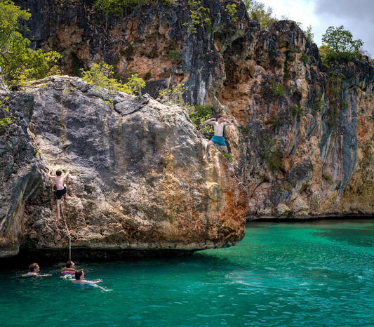 A family swimming and jumping off rocks on a luxury travel vacation