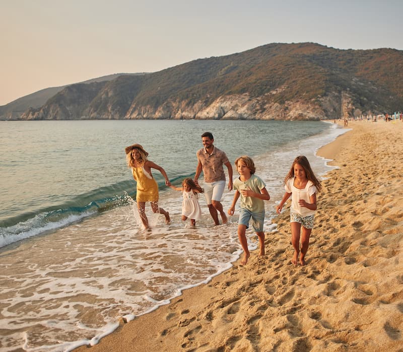 A family of five playing on the beach during a luxury family vacation