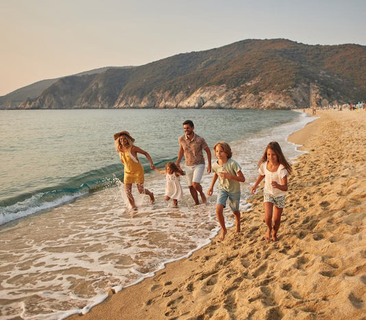 A family of five playing on the beach during a luxury family vacation