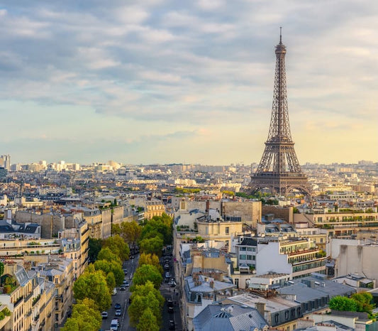 A sunset view of the Paris skyline, including the Eiffel tower, a central feature in many luxury Paris itineraries