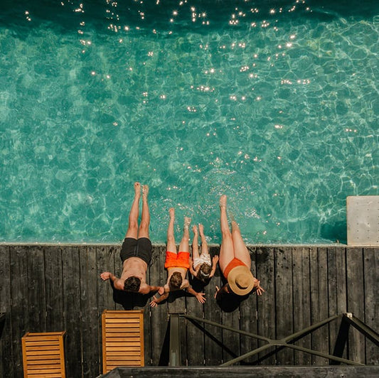 A family of four sitting poolside at a top family luxury resort